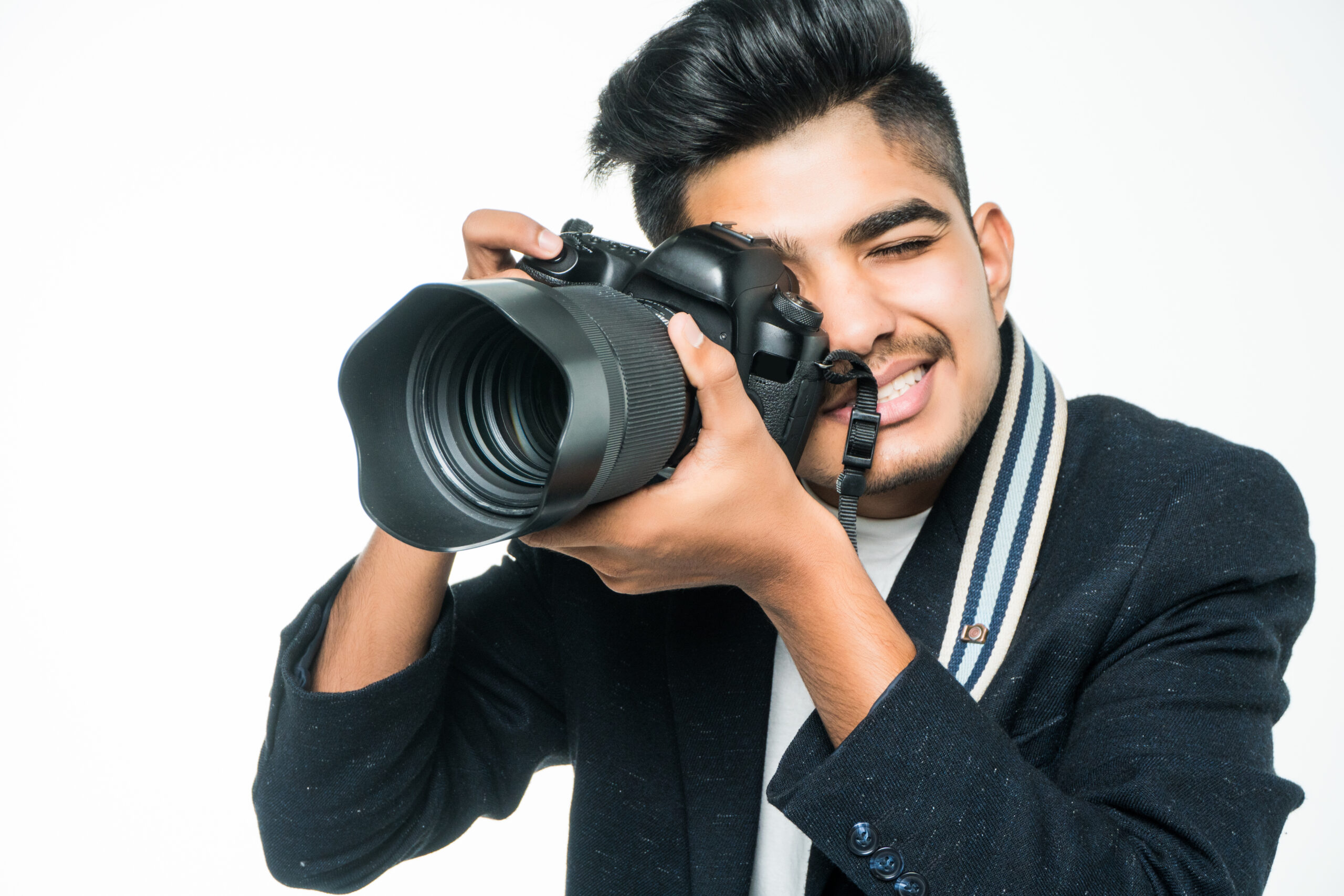 Indian photographer man holding his camera isolated on a white background.