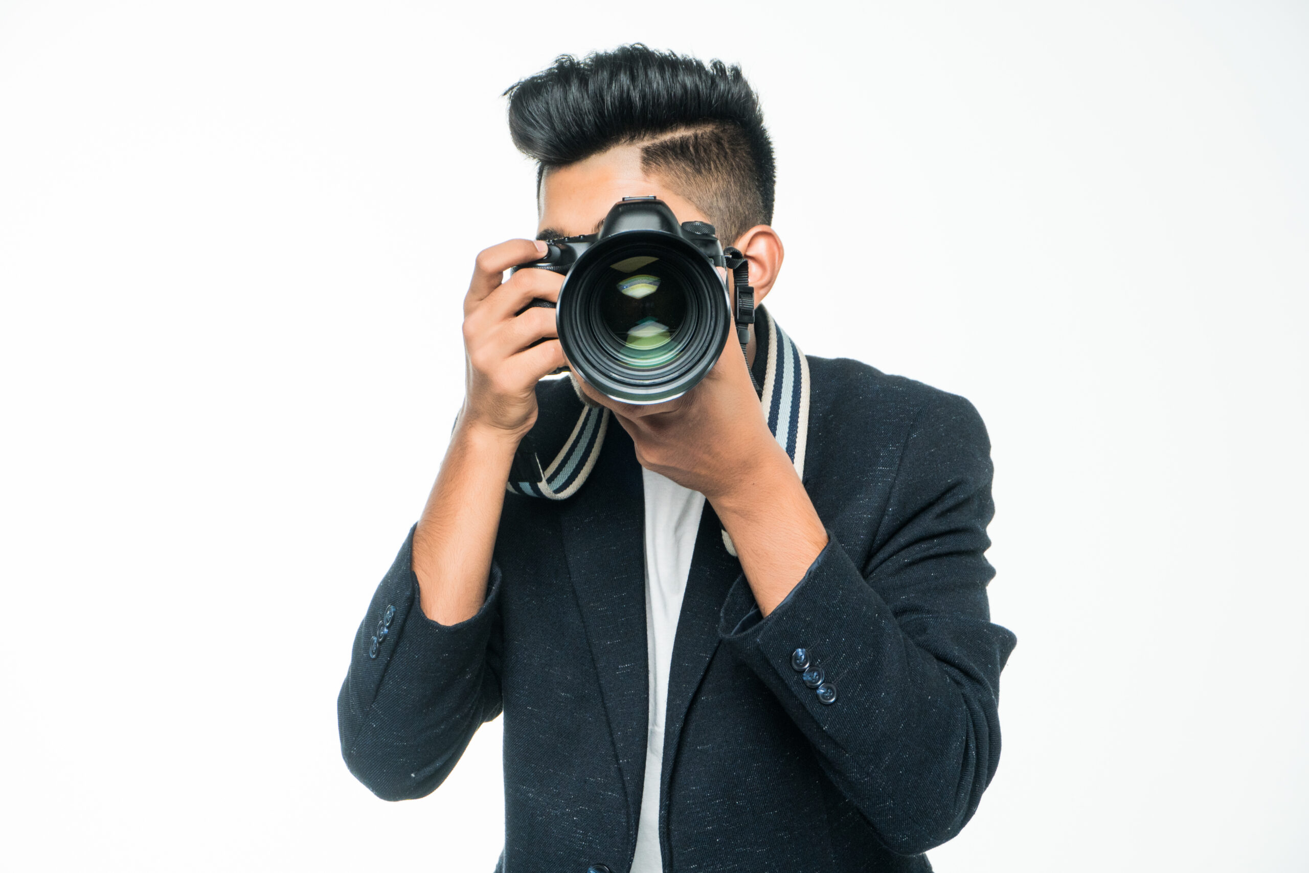 Young Asian man with camera isolated on white background.